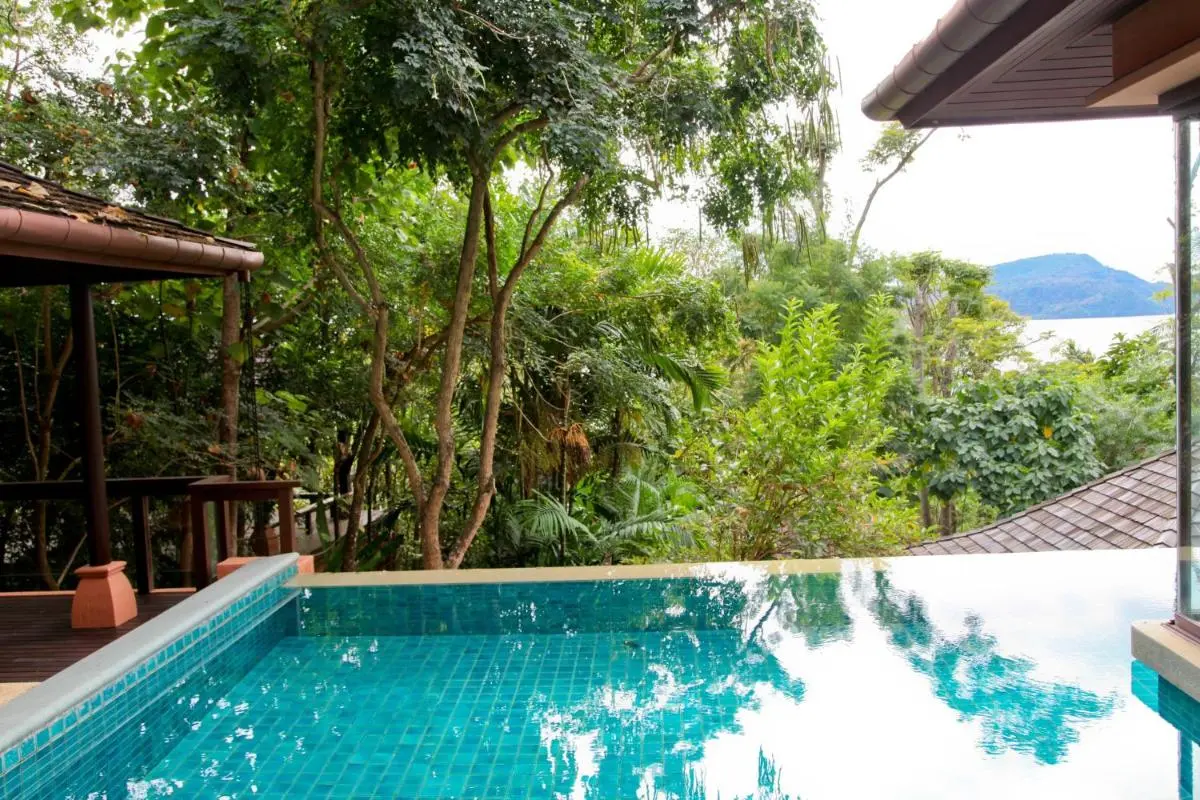 Outdoor Infinity Pool with Wooden Deck and Scenic Water Views at Panwa Beach