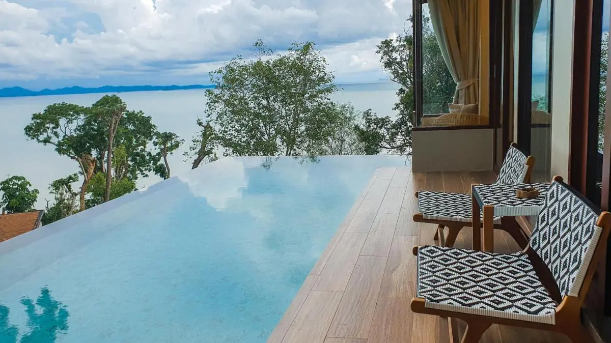 Outdoor Infinity Pool with Wooden Deck and Scenic Water Views in Phuket Town