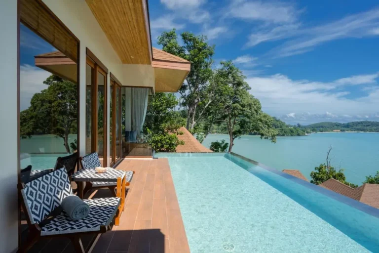 Outdoor Infinity Pool with Wooden Deck and Scenic Waterfront View in Phuket Town