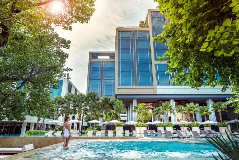 Outdoor Jacuzzi and Swimming Pool Area with Lounge Chairs and Palm Trees in Sathorn Bangkok