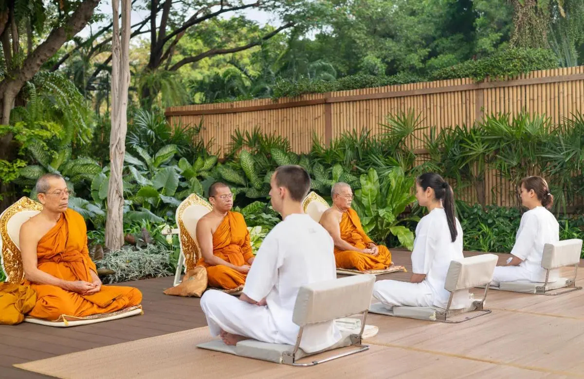 Outdoor Meditation Session on Wooden Deck Surrounded by Tropical Greenery in Khlong San Bangkok