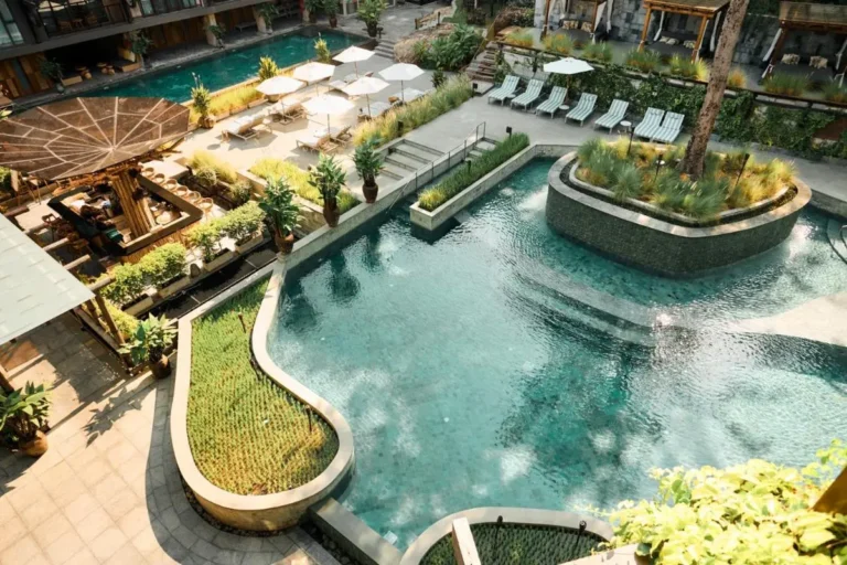 Outdoor Multi-Level Pool Area with Lounge Seating and Natural Landscaping at Patong Beach