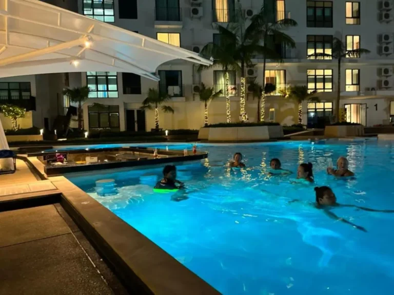 Outdoor Nighttime Swimming Pool with Swim-Up Bar and Ambient Lighting at Rawai Beach