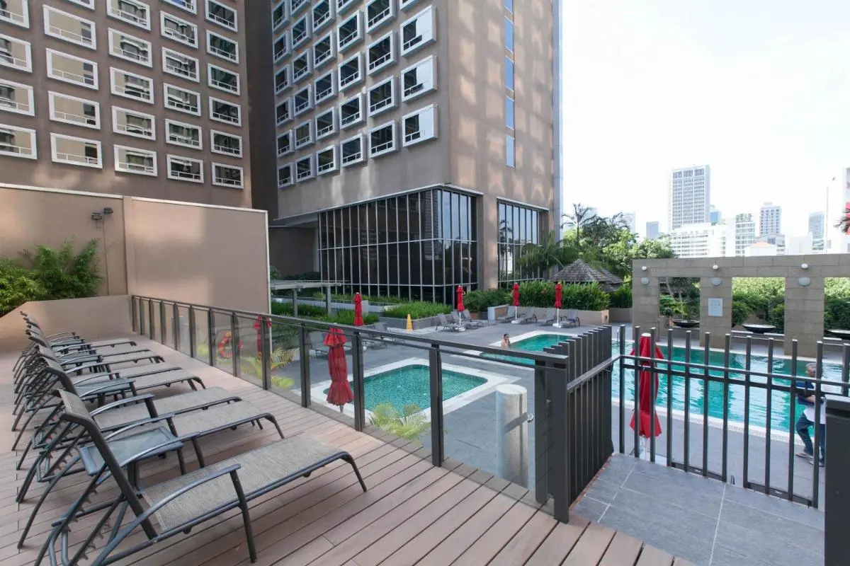 Outdoor Pool and Spa Area with Jacuzzi and Lounge Seating Near City Hall