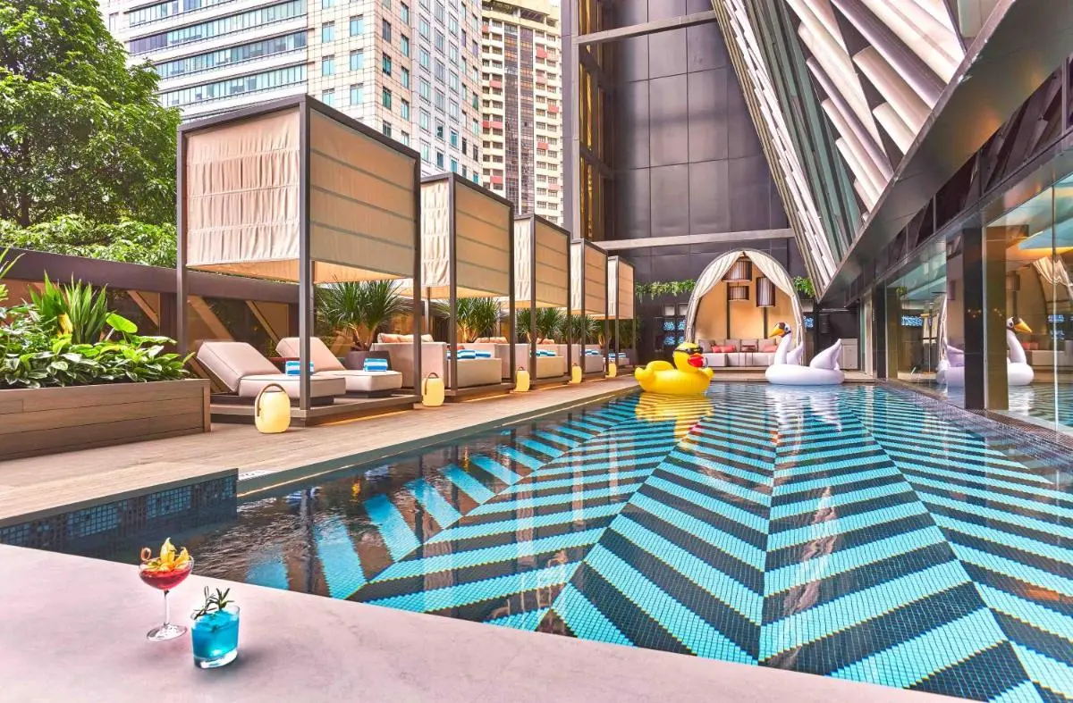 Outdoor Pool Area with Cabanas and Lounge Seating in Orchard Singapore