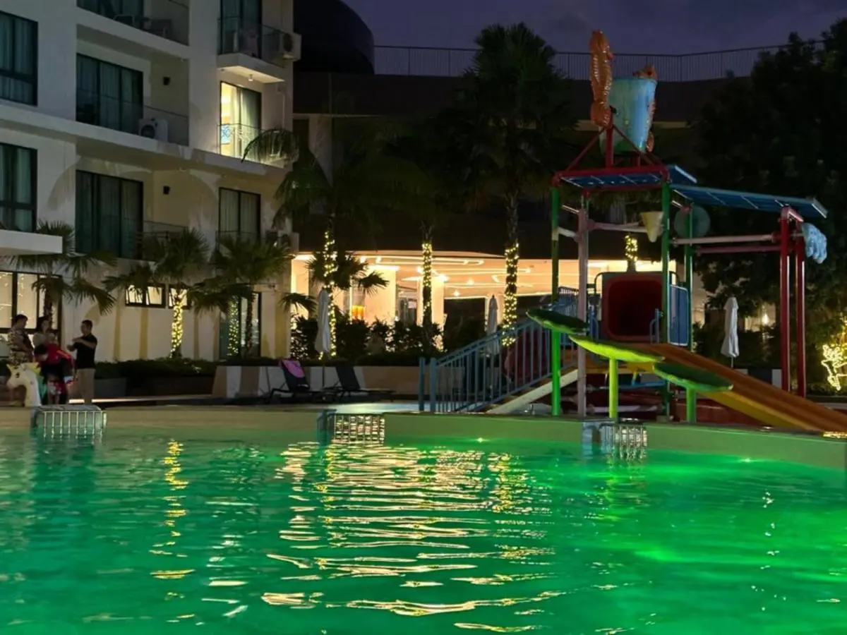 Outdoor Pool Area with Children’s Play Structure and Green Lighting at Night in Rawai Beach