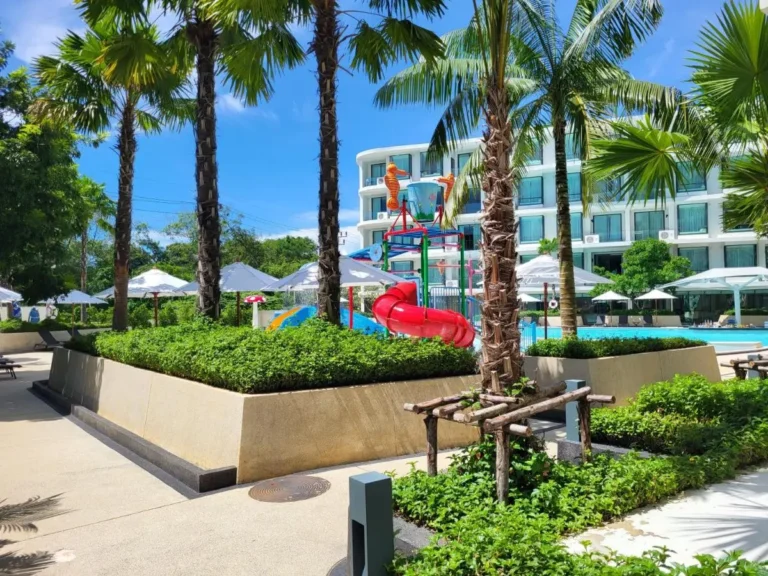 Outdoor Pool Area with Children’s Play Structure and Palm Trees at Rawai Beach Resort