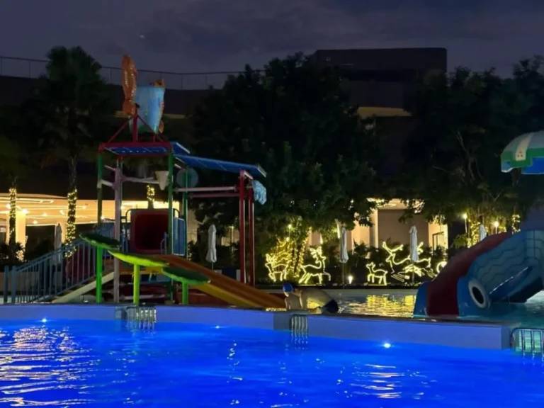 Outdoor Pool Area with Children’s Water Slide and Festive Lighting at Night in Rawai Beach