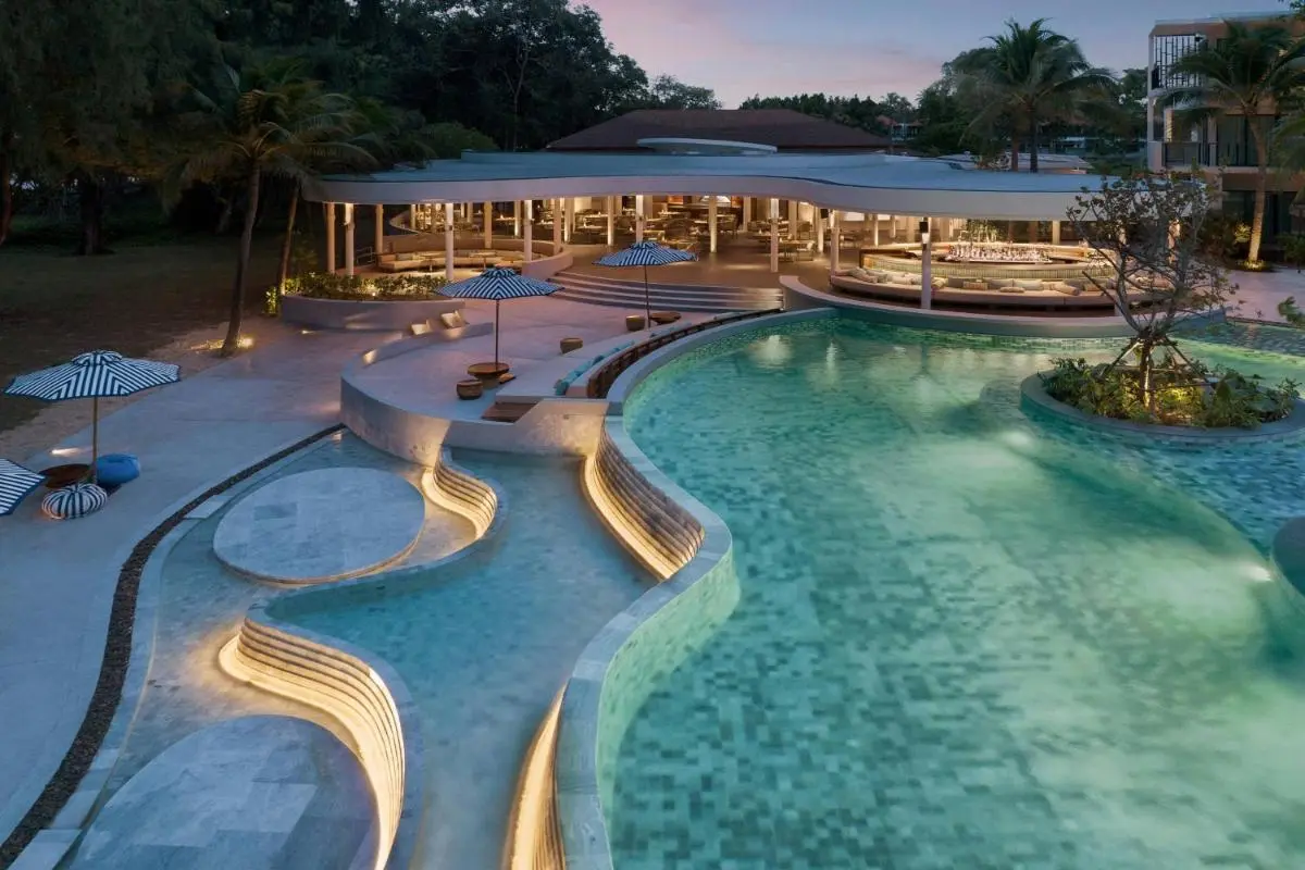 Le Meridien Phuket Mai Khao Beach Resort Outdoor Pool Area with Curved Roof Building and Organic Shaped Pool at Mai Khao Beach