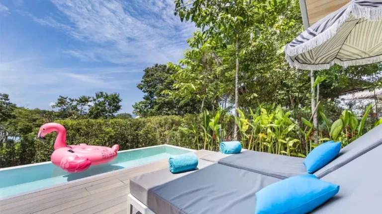 Outdoor Pool Area with Flamingo Float and Cushioned Lounge Chairs in Phuket Town