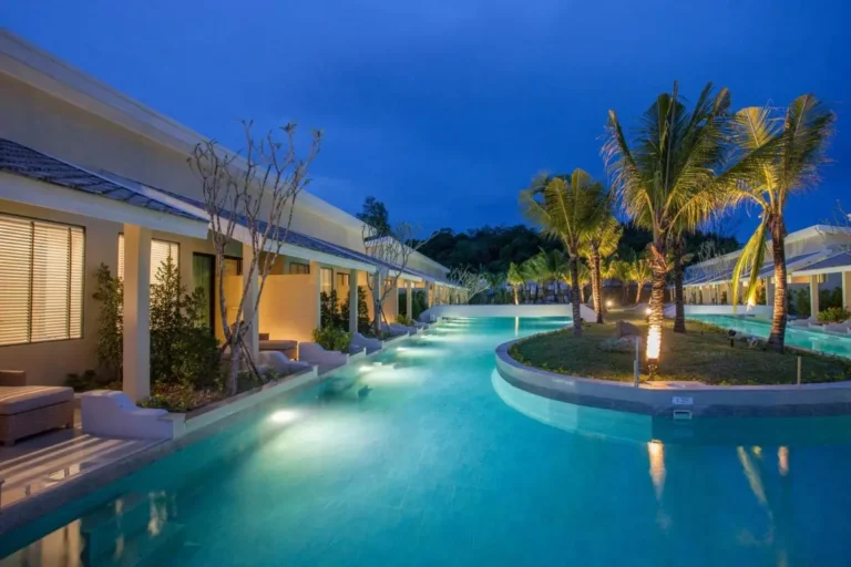 Outdoor Pool Area with Illuminated Palm Trees and Modern Architecture in Phuket Town
