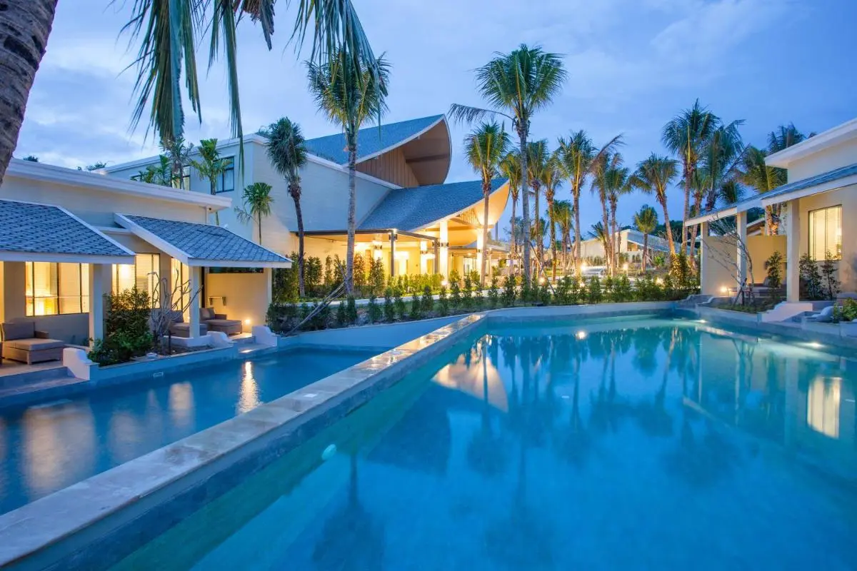 Outdoor Pool Area with Illuminated Water Features and Tropical Landscaping in Phuket Town