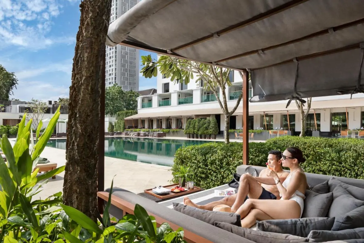 The Sukhothai Bangkok Outdoor Pool Area with Lounge Cabanas and Daybed Seating in Sathorn Urban Setting