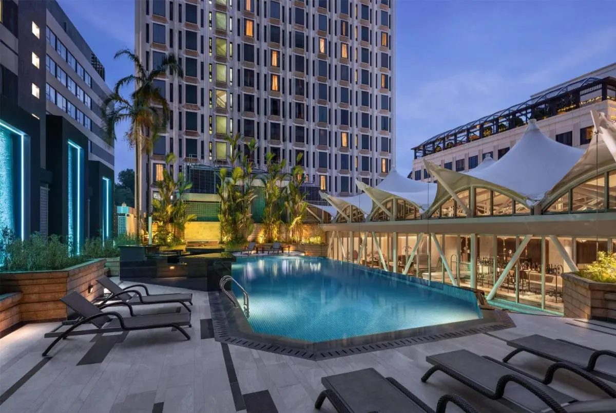 Outdoor Pool Area with Lounge Chairs and Glass-Walled Facility Near City Hall