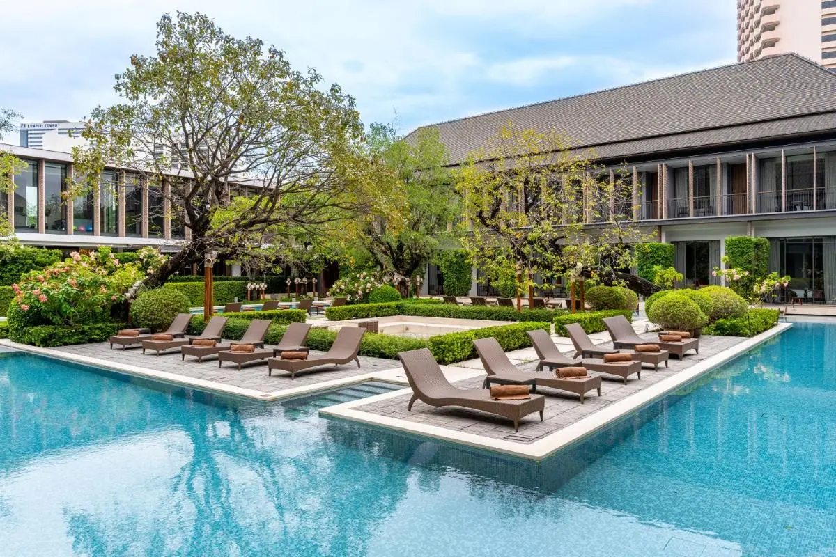 Outdoor Pool Area with Lounge Chairs and Greenery in Sathorn Courtyard