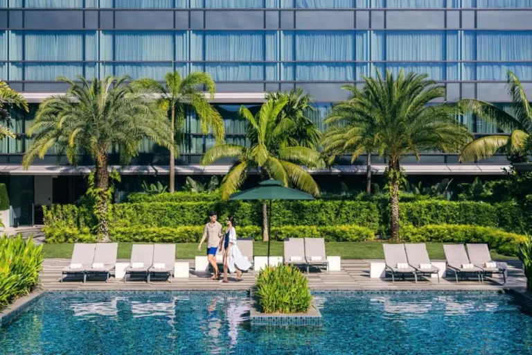Outdoor Pool Area with Lounge Chairs and Greenery in Singapore