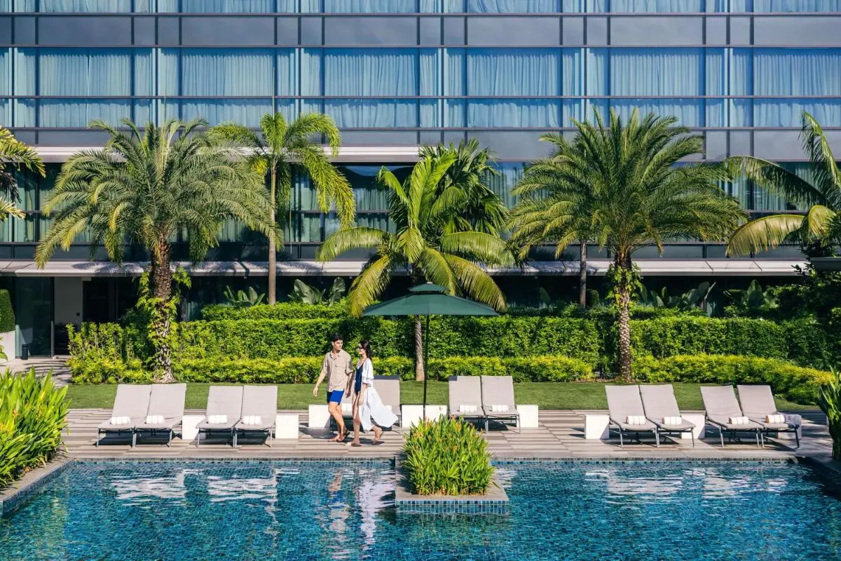 Outdoor Pool Area with Lounge Chairs and Greenery in Singapore