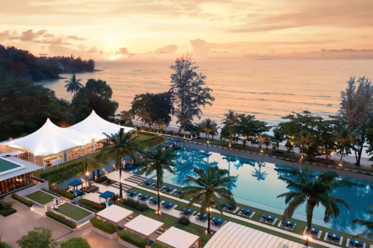 Outdoor Pool Area with Lounge Chairs and Palm Trees at Kamala Beach Sunset