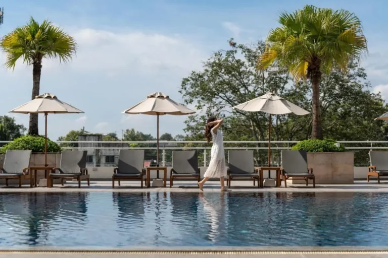 Outdoor Pool Area with Lounge Chairs and Palm Trees in Chiang Mai City
