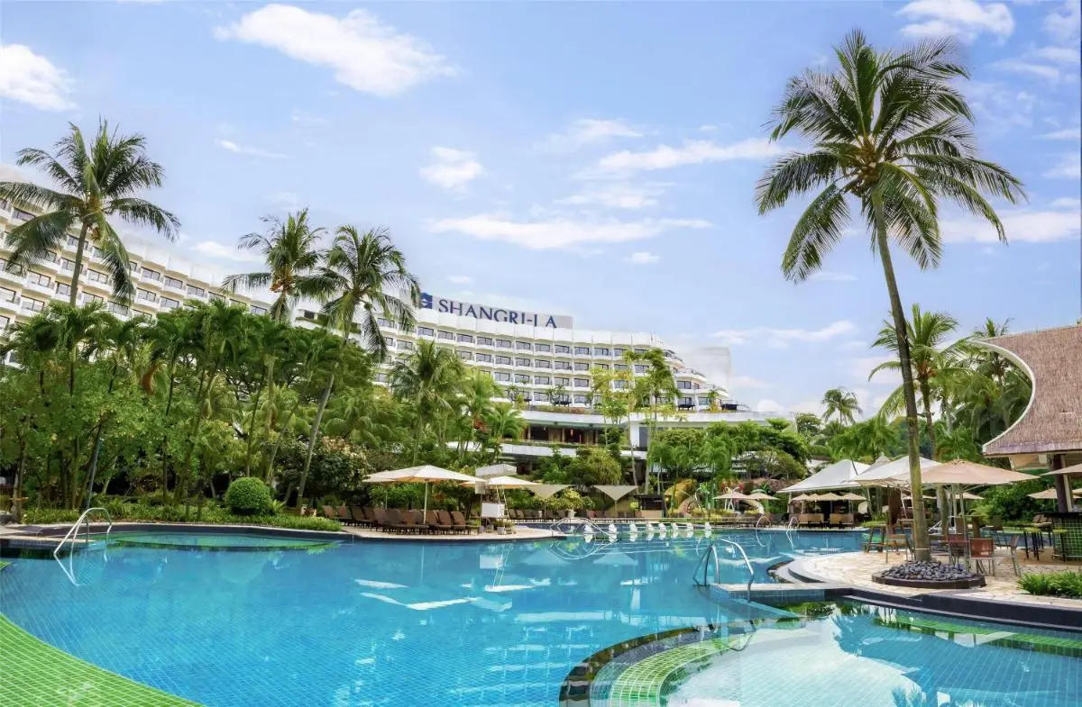 Outdoor Pool Area with Lounge Chairs and Thatched-Roof Seating in Singapore