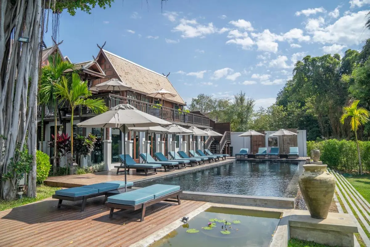 Outdoor Pool Area with Lounge Chairs and Traditional Architecture in Fa Ham Chiang Mai