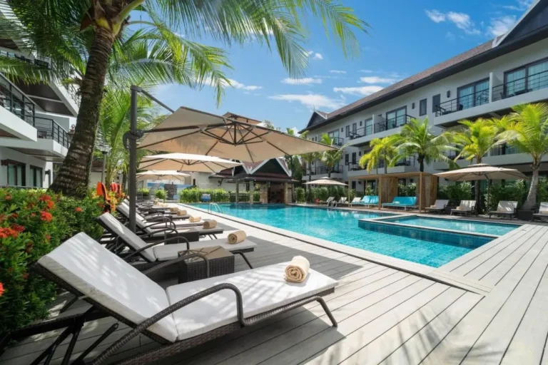 Outdoor Pool Area with Lounge Chairs and Tropical Landscaping in Thalang