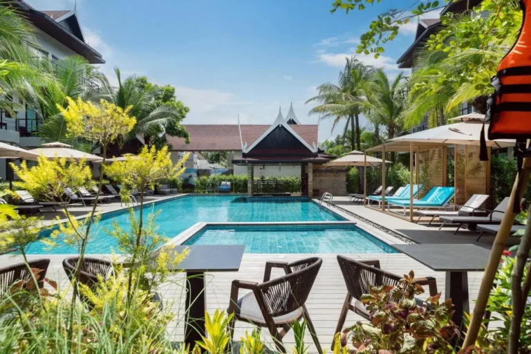 Outdoor Pool Area with Lounge Chairs and Tropical Vegetation in Thalang