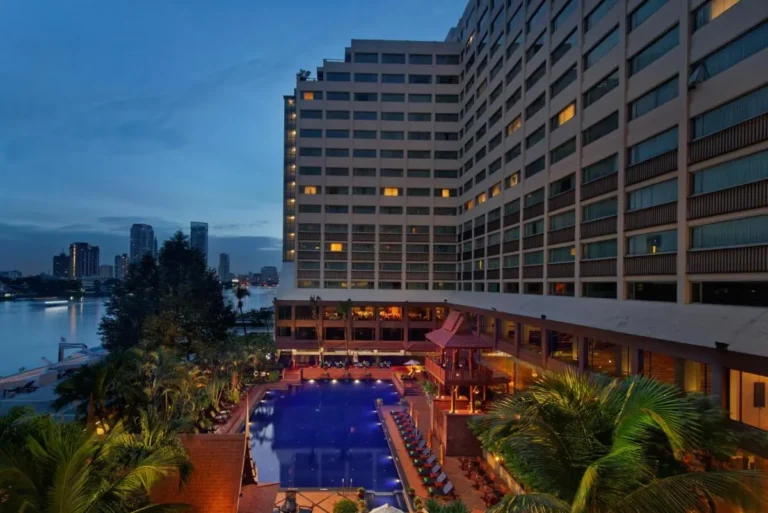 Outdoor Pool Area with Lounge Chairs and Urban Waterfront View in Bang Kho Laem Bangkok