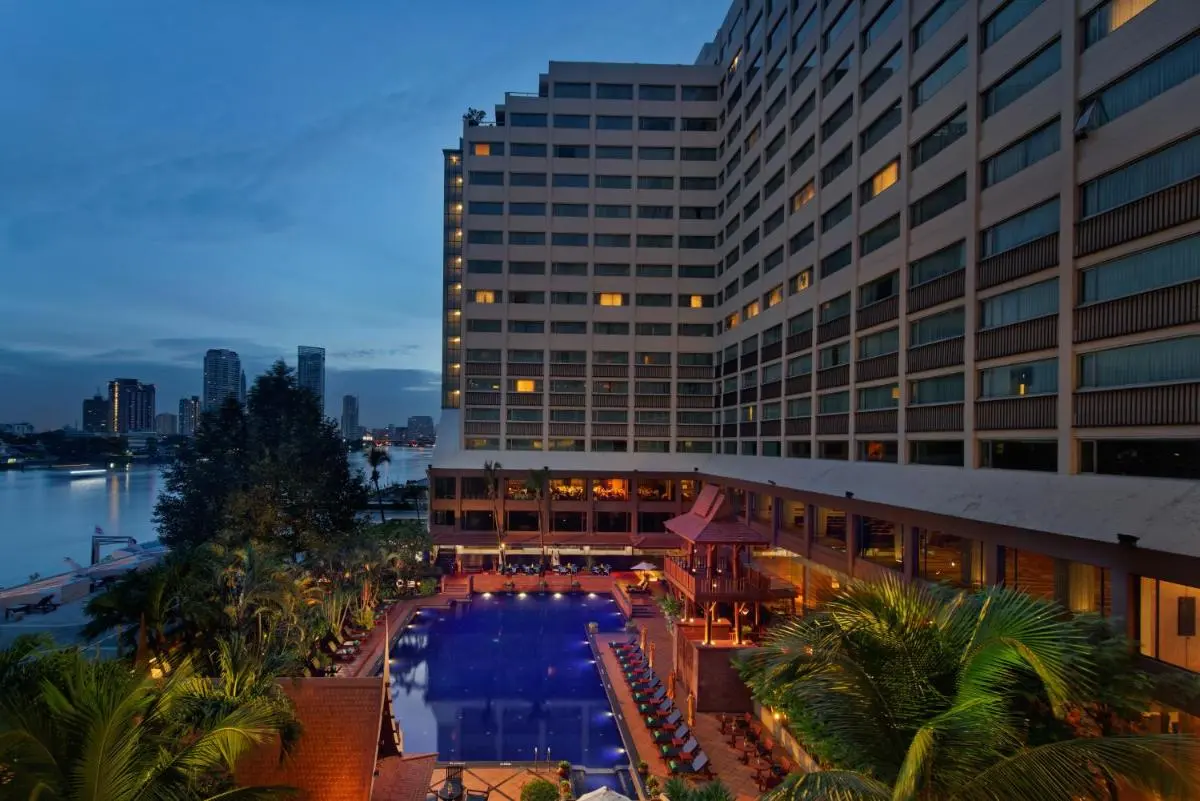 Outdoor Pool Area with Lounge Chairs and Urban Waterfront View in Bang Kho Laem Bangkok
