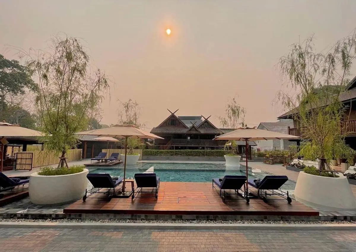 Outdoor Pool Area with Lounge Chairs and Wooden Deck in Chiang Mai Courtyard