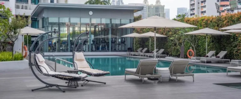 Outdoor Pool Area with Lounge Seating and Fitness Center in Singapore