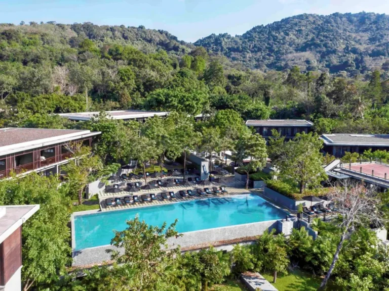 Outdoor Pool Area with Lounge Seating and Forested Hills at Nai Thon Beach