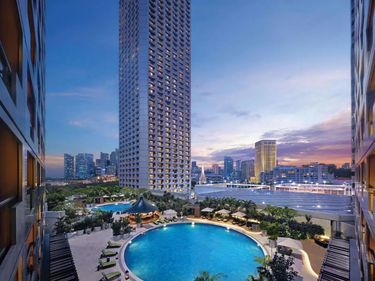Swissotel The Stamford Singapore Outdoor Pool Area with Lounge Seating and Tropical Landscaping Near City Hall