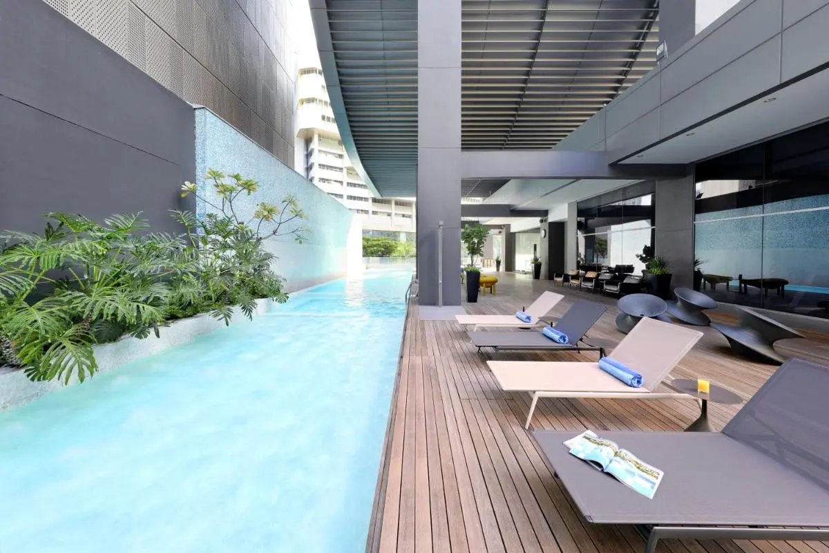 Outdoor Pool Area with Water Feature and Lounge Seating in Singapore