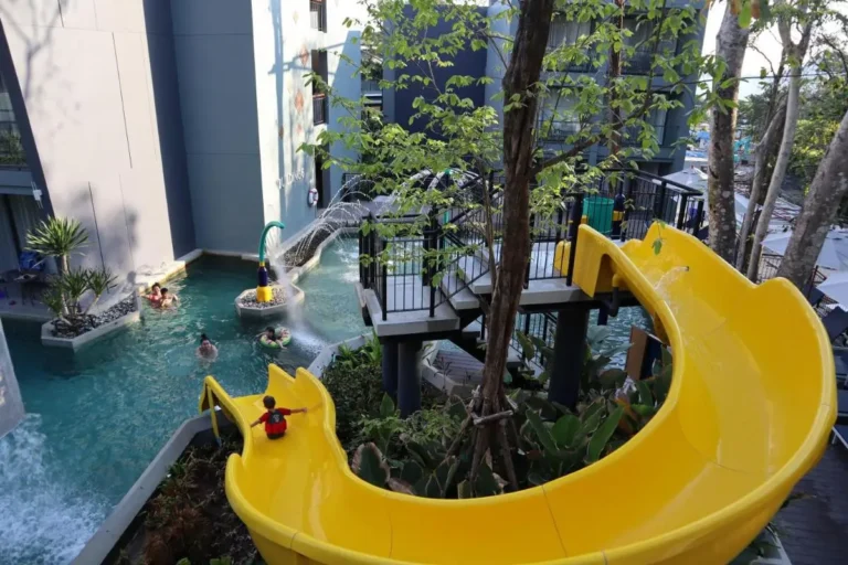 Outdoor Pool Area with Water Slide and Decorative Water Features at Patong Beach