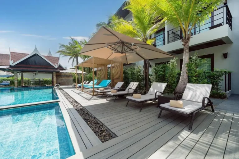 Outdoor Pool Area with Wooden Deck and Lounge Chairs in Thalang