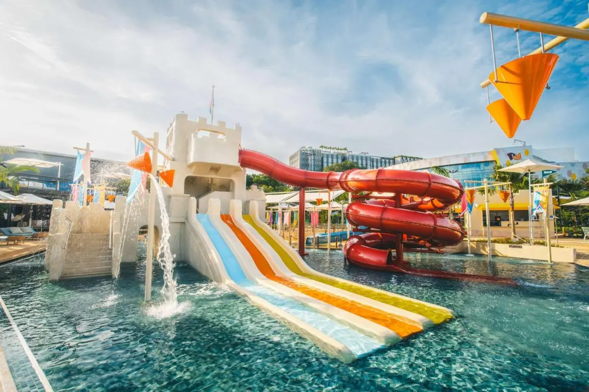 Outdoor Pool with Multiple Water Slides and Play Structures in Singapore