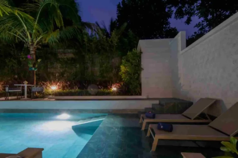 Outdoor Rectangular Pool Area with Lounge Seating and Ambient Lighting at Night in Phuket Town
