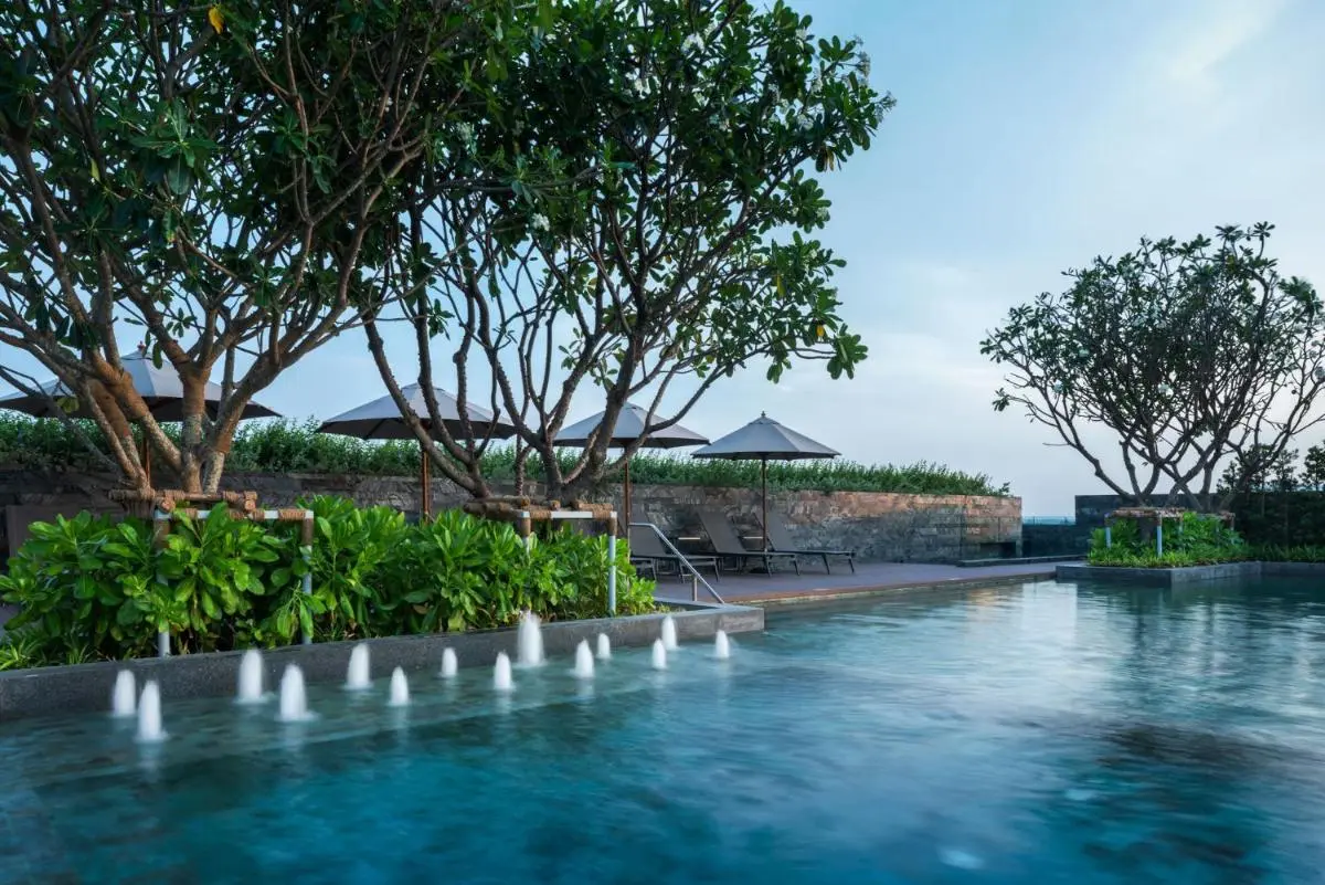 Outdoor Rectangular Pool with Water Jets and Shaded Lounge Area in Phuket Town