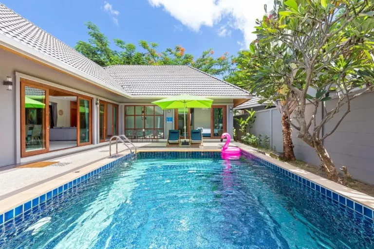 Outdoor Rectangular Swimming Pool with Flamingo Inflatable and Lounge Area at Rawai Beach