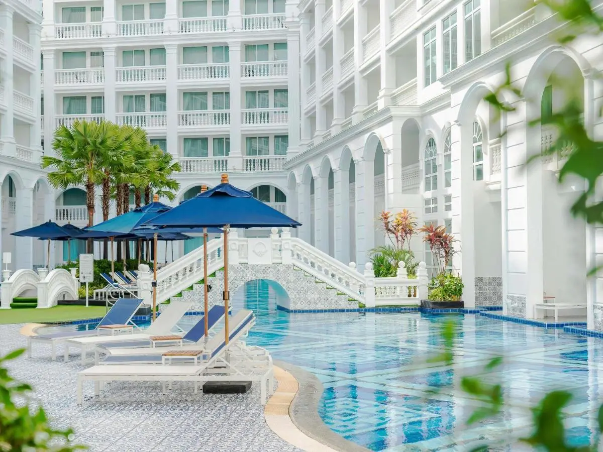 Outdoor Rectangular Swimming Pool with Lounge Chairs and Blue Umbrellas at Patong Beach