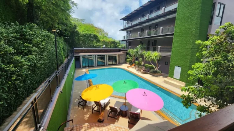 Outdoor Rectangular Swimming Pool with Lounge Chairs and Colorful Umbrellas in Ban Bo Rae