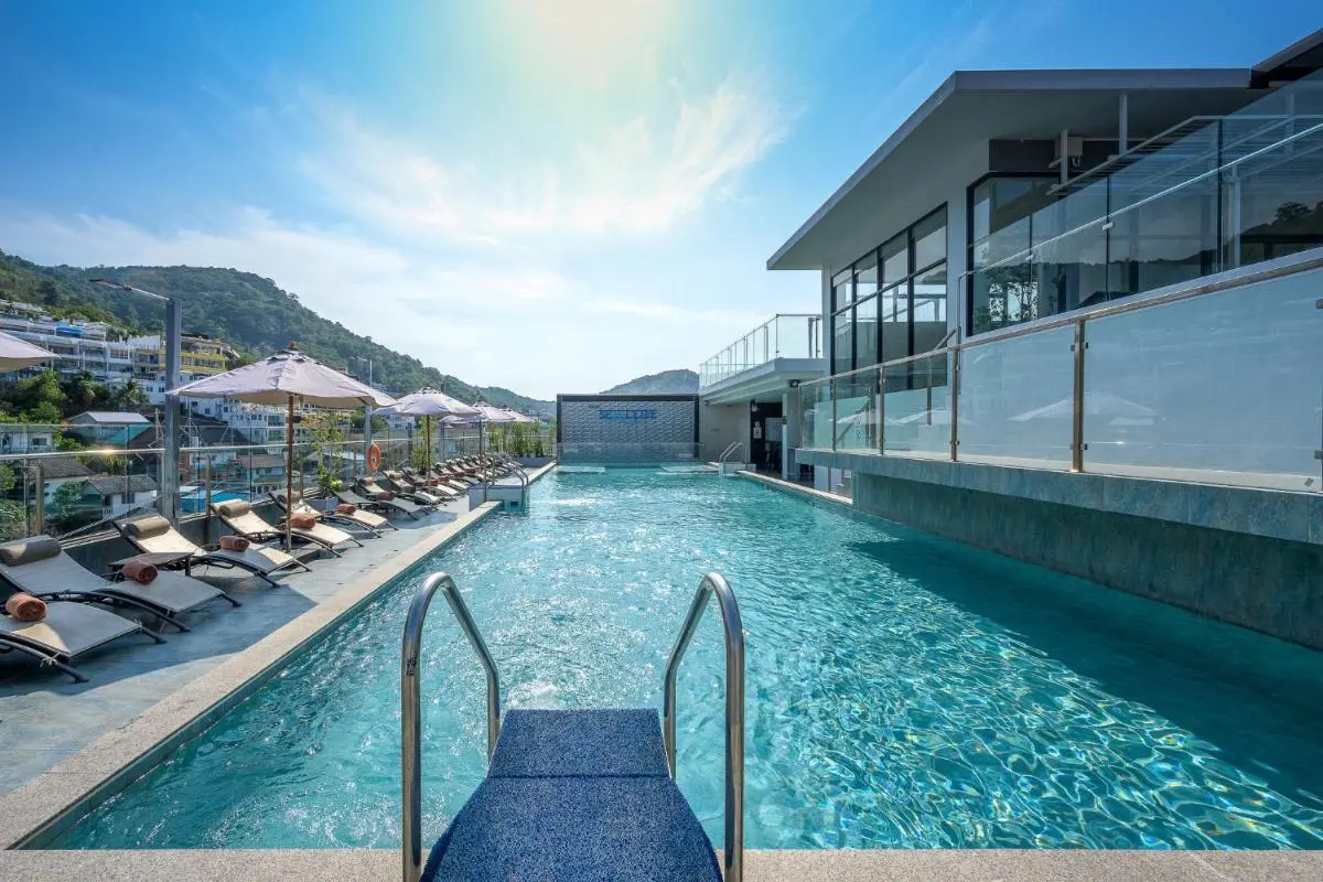 Outdoor Rectangular Swimming Pool with Lounge Chairs and Glass Railings at Patong Beach
