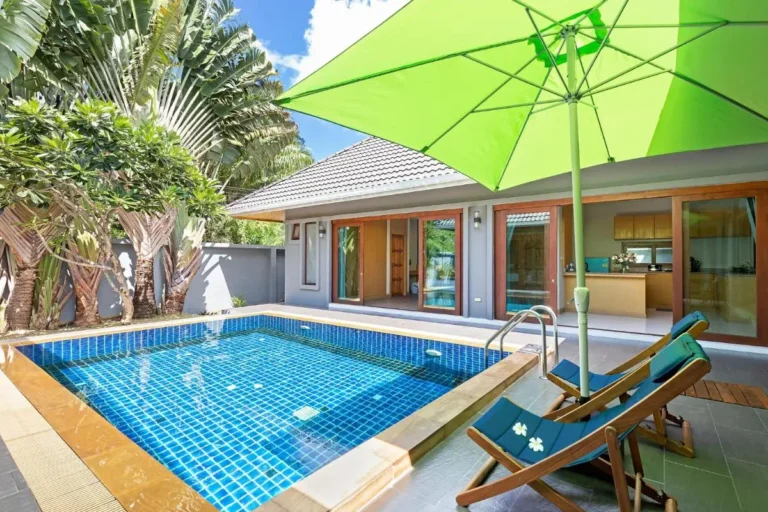 Outdoor Rectangular Swimming Pool with Lounge Chairs and Green Umbrella at Rawai Beach