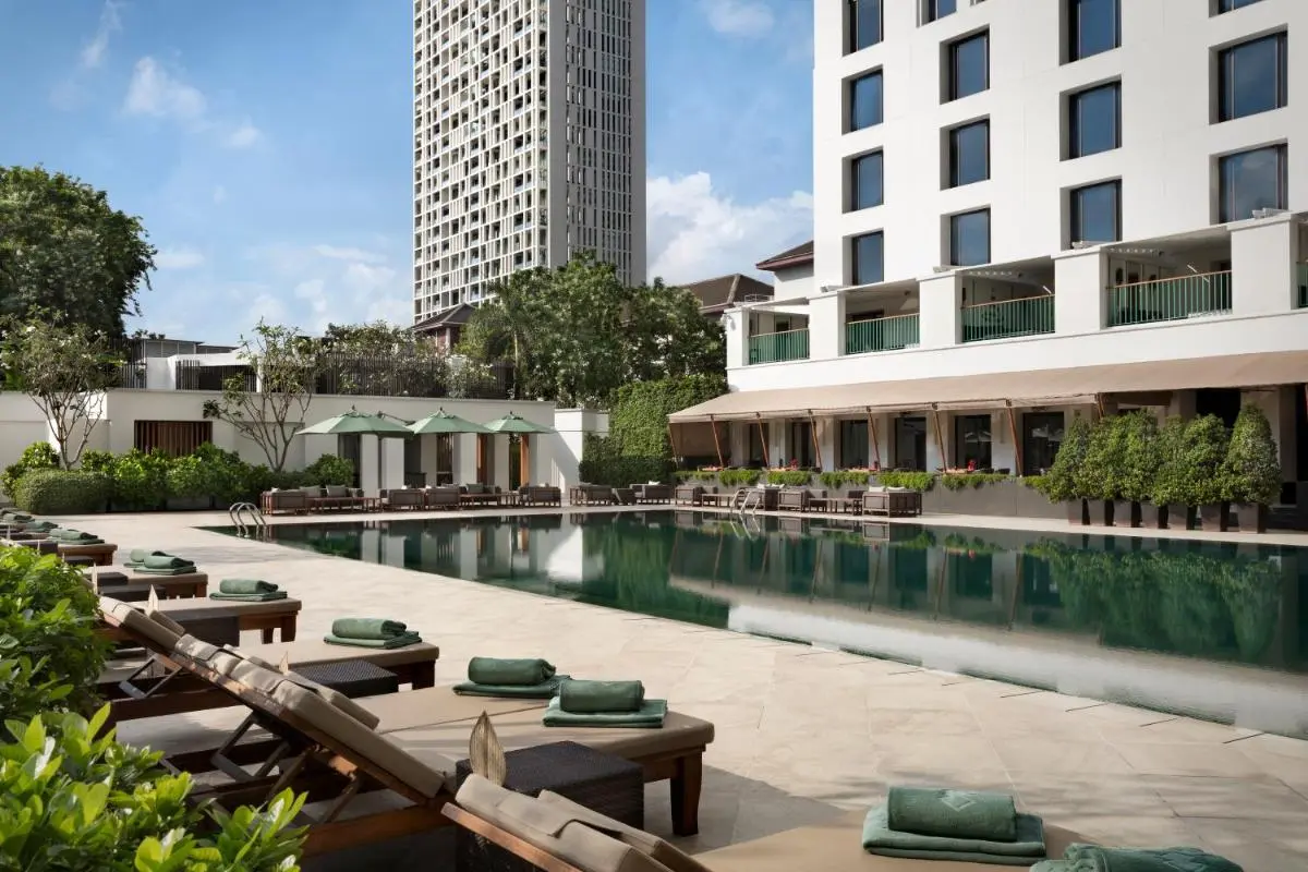 Outdoor Rectangular Swimming Pool with Lounge Chairs and Green Umbrellas in Sathorn Bangkok