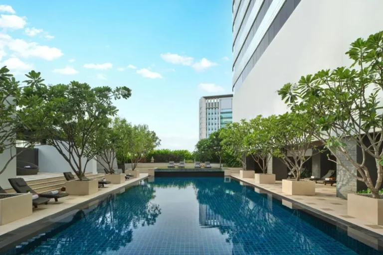 Outdoor Rectangular Swimming Pool with Lounge Chairs and Greenery in Khlong Toei Bangkok