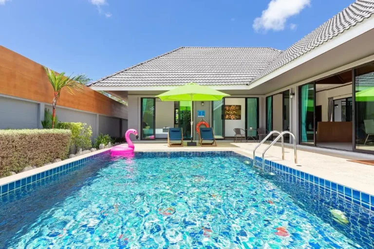 Outdoor Rectangular Swimming Pool with Lounge Chairs and Inflatable Flamingo Float at Rawai Beach