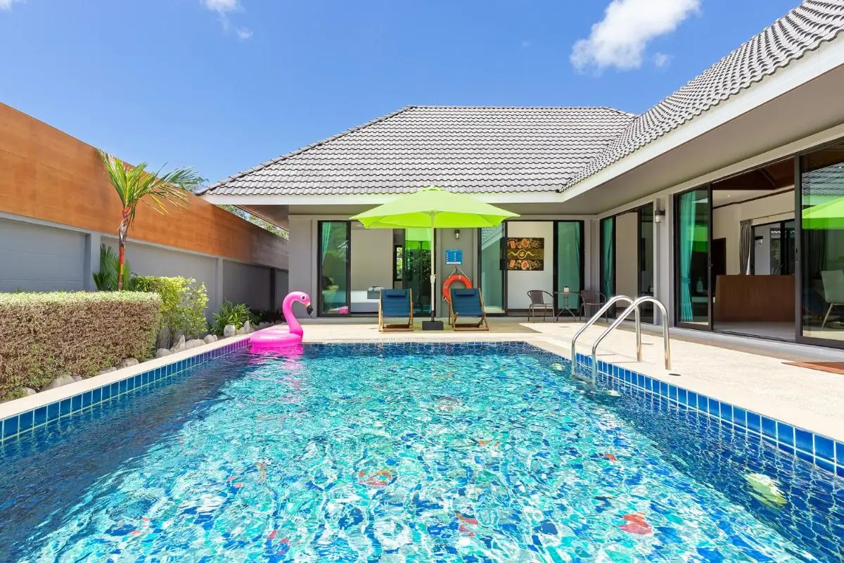 Outdoor Rectangular Swimming Pool with Lounge Chairs and Inflatable Flamingo Float at Rawai Beach
