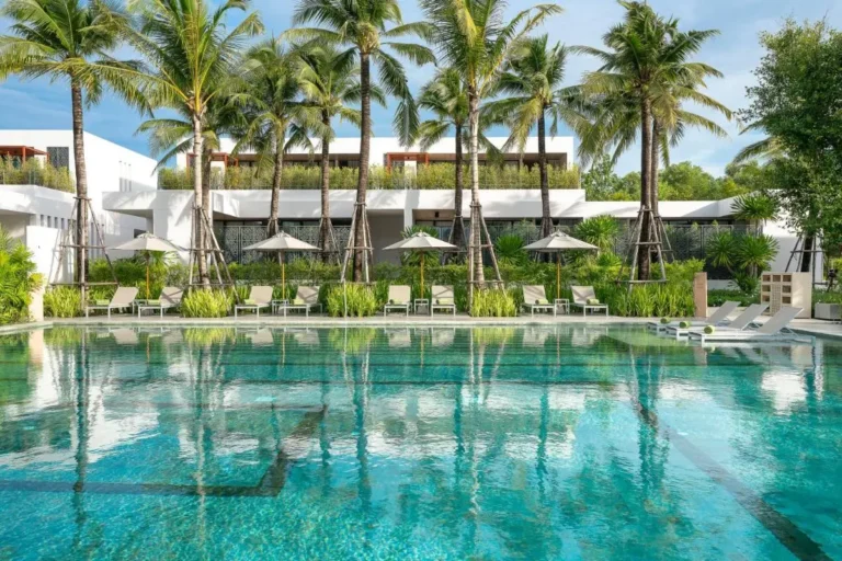 Outdoor Rectangular Swimming Pool with Lounge Chairs and Palm Trees at Mai Khao Beach