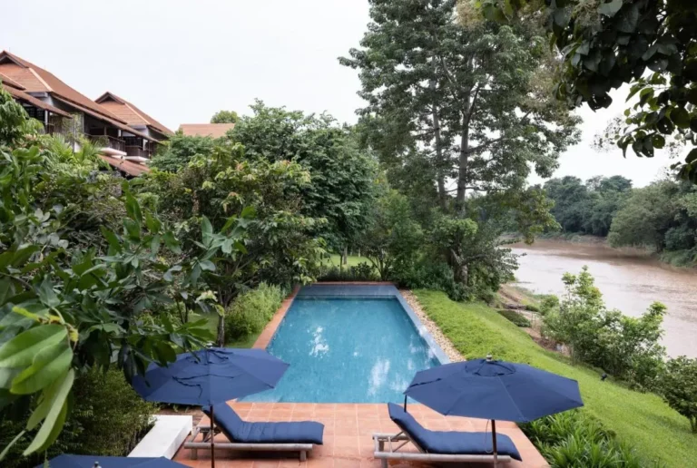 Outdoor Rectangular Swimming Pool with Lounge Chairs and River View in Chiang Mai